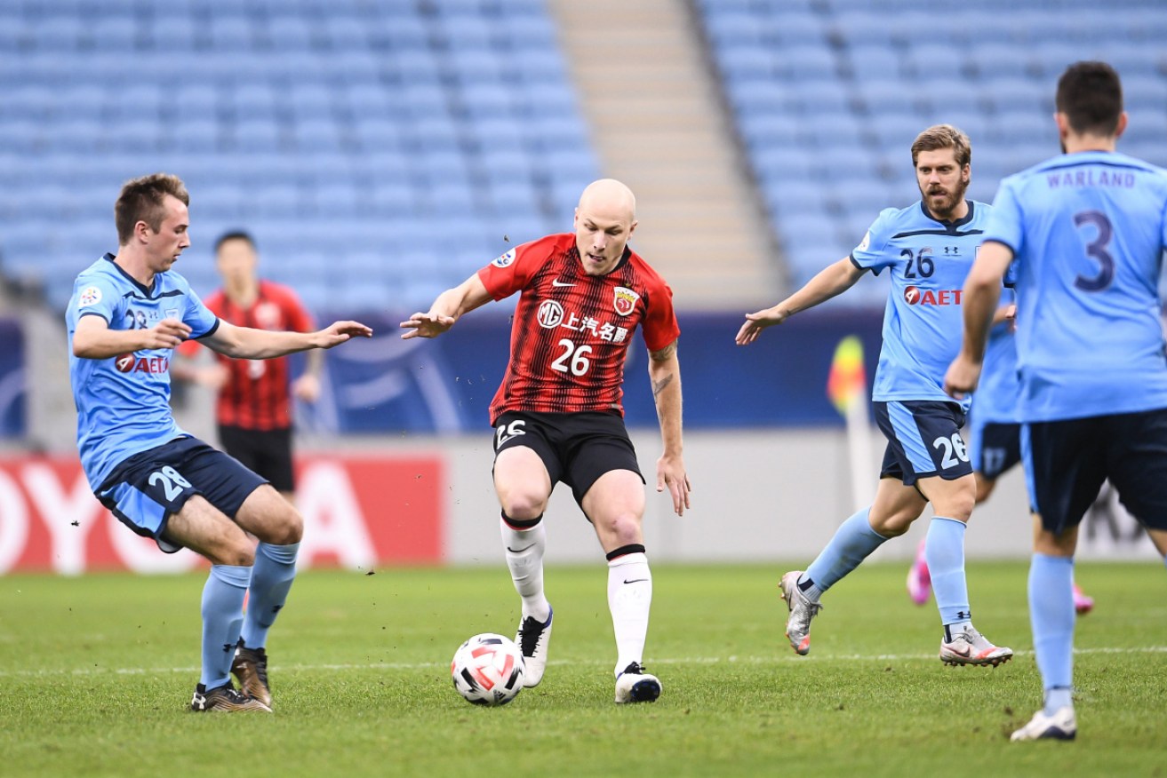 Shanghai SIPG’s Aaron Mooy shields the ball from Sydney FC opponents in Doha in December. 
