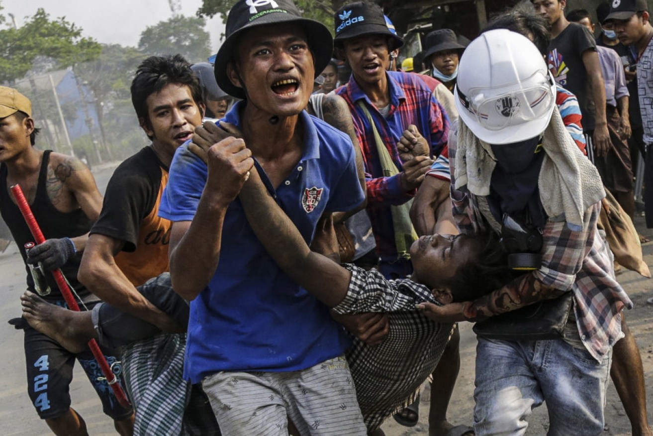 An injured demonstrator is carried to receive medical attention during a protest against the military coup in Hlaingthaya township, on the outskirts of Yangon on Sunday.