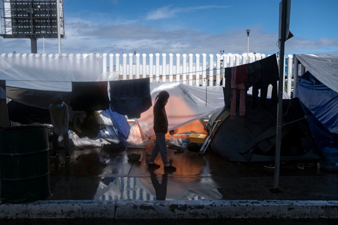 A migrant girl walks at an improvised camp outside El Chaparral crossing port as her and other wait for US authorities to allow them to start their migration process.