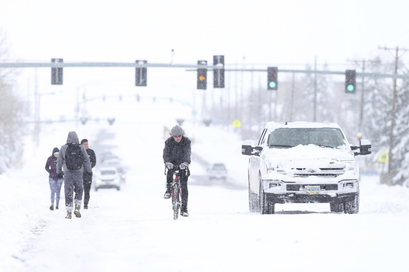 Denver's airport reopens after powerful late-winter snowstorm dumps 100cm of heavy, wet snow on parts of Colorado and Wyoming, shutting down roads, closing state legislatures in both states, and interfering with COVID-19 vaccinations.