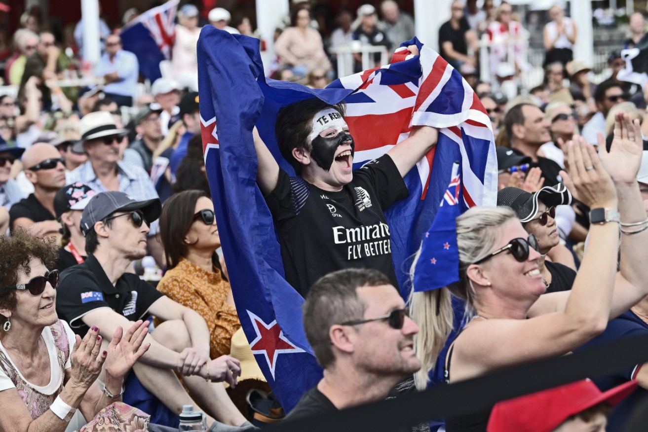 Team New Zealand supporters celebrate the race nine win on Auckland's Waitemata Harbour on Tuesday.