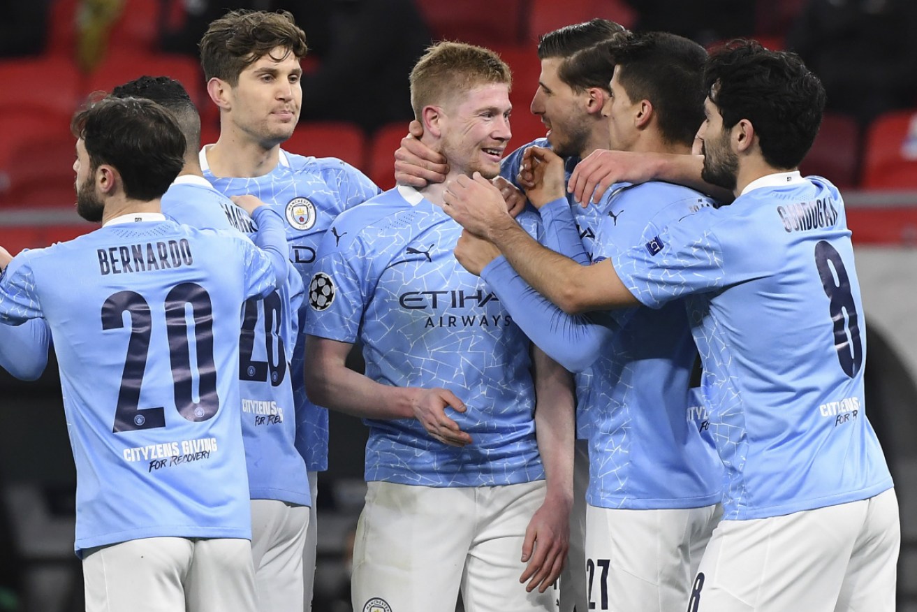 Kevin De Bruyne of Manchester City, centre, celebrates with teammates after scoring the opening goal against Borussia Moenchengladbach.