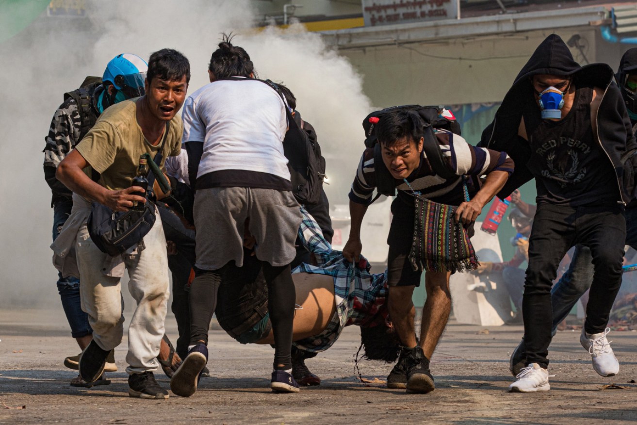 Protesters carry a wounded man shot with live rounds by security forces.