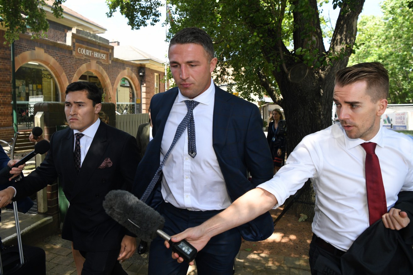 Burgess (centre) leaves Moss Vale Local Court after a hearing in February.