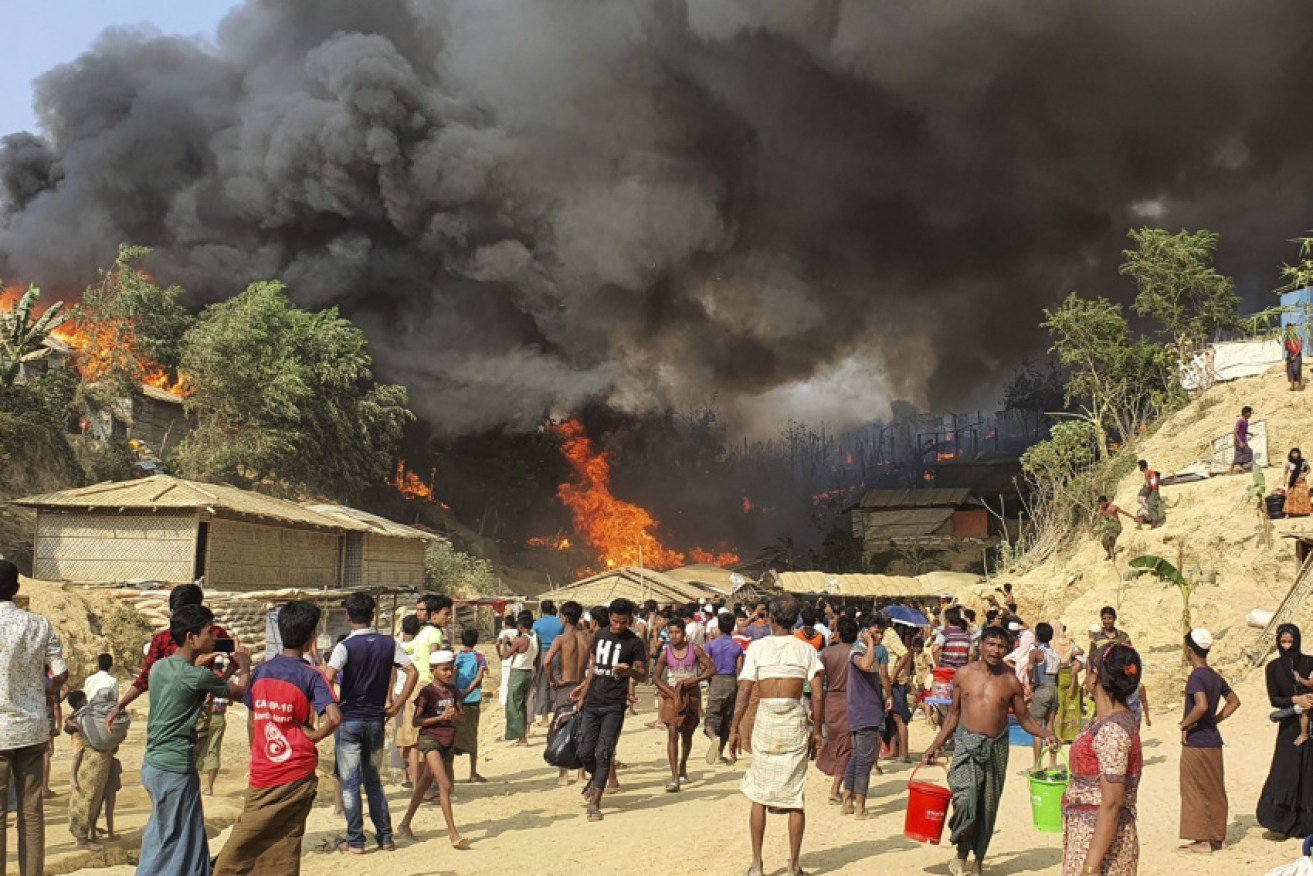 Residents watch on as the fire engulfs the Rohingya refugee camp in Balukhali, Bangladesh.