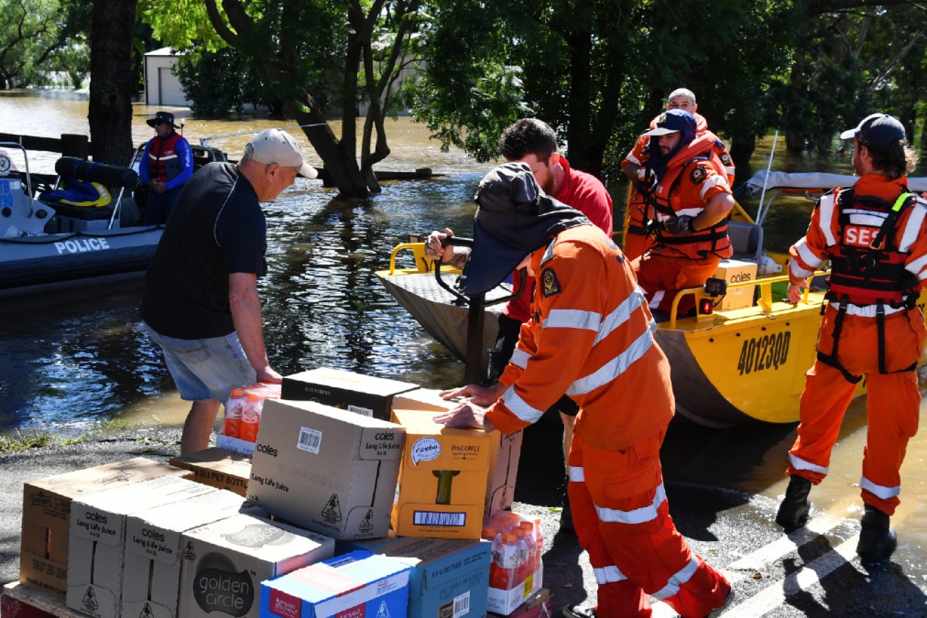 SES crews, police and local residents load boats with supplies for cut-off households in the Windsor area.