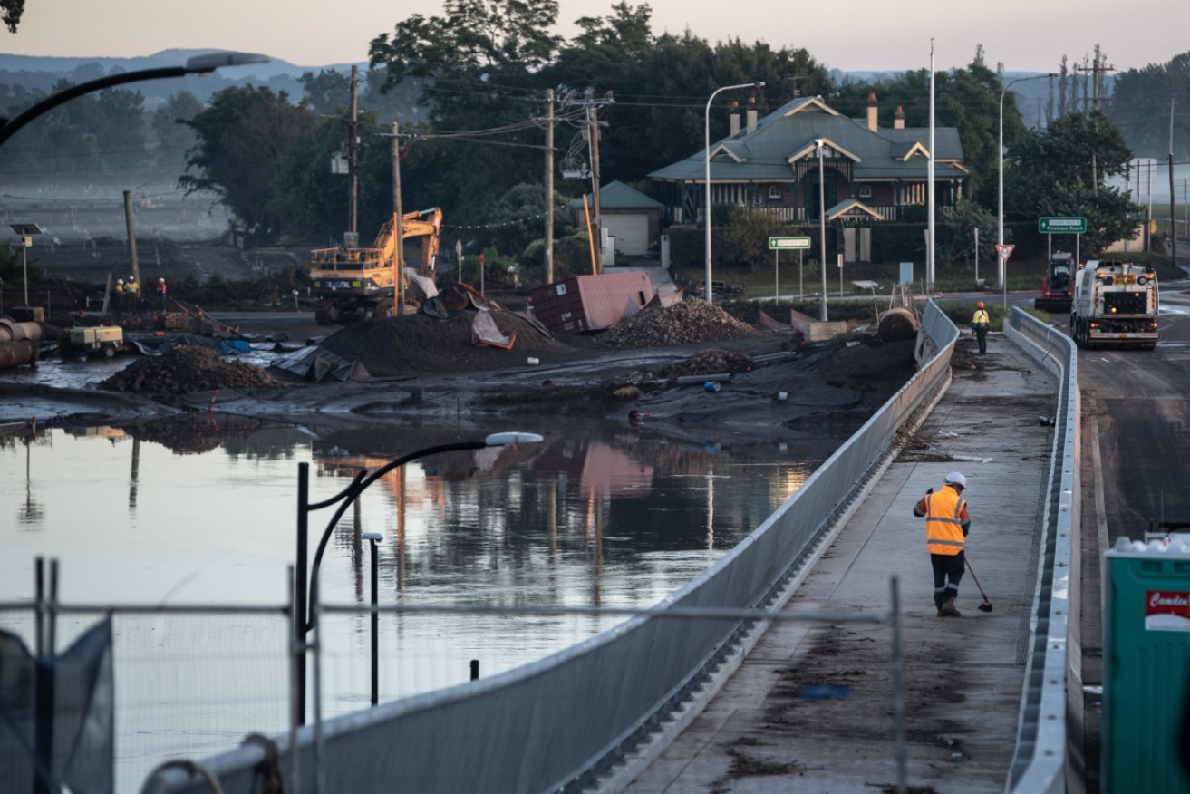 Workers clearing debris from the New Windsor Bridge which was underwater during the recent floods.