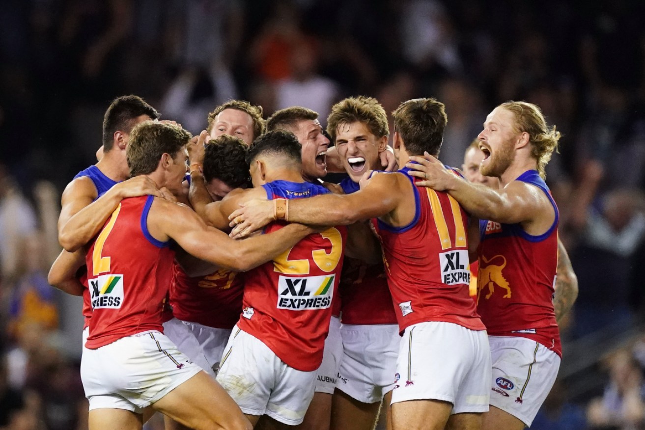 Zac Bailey is mobbed by his Lions teammates at Marvel Stadium in Melbourne on Thursday night. 