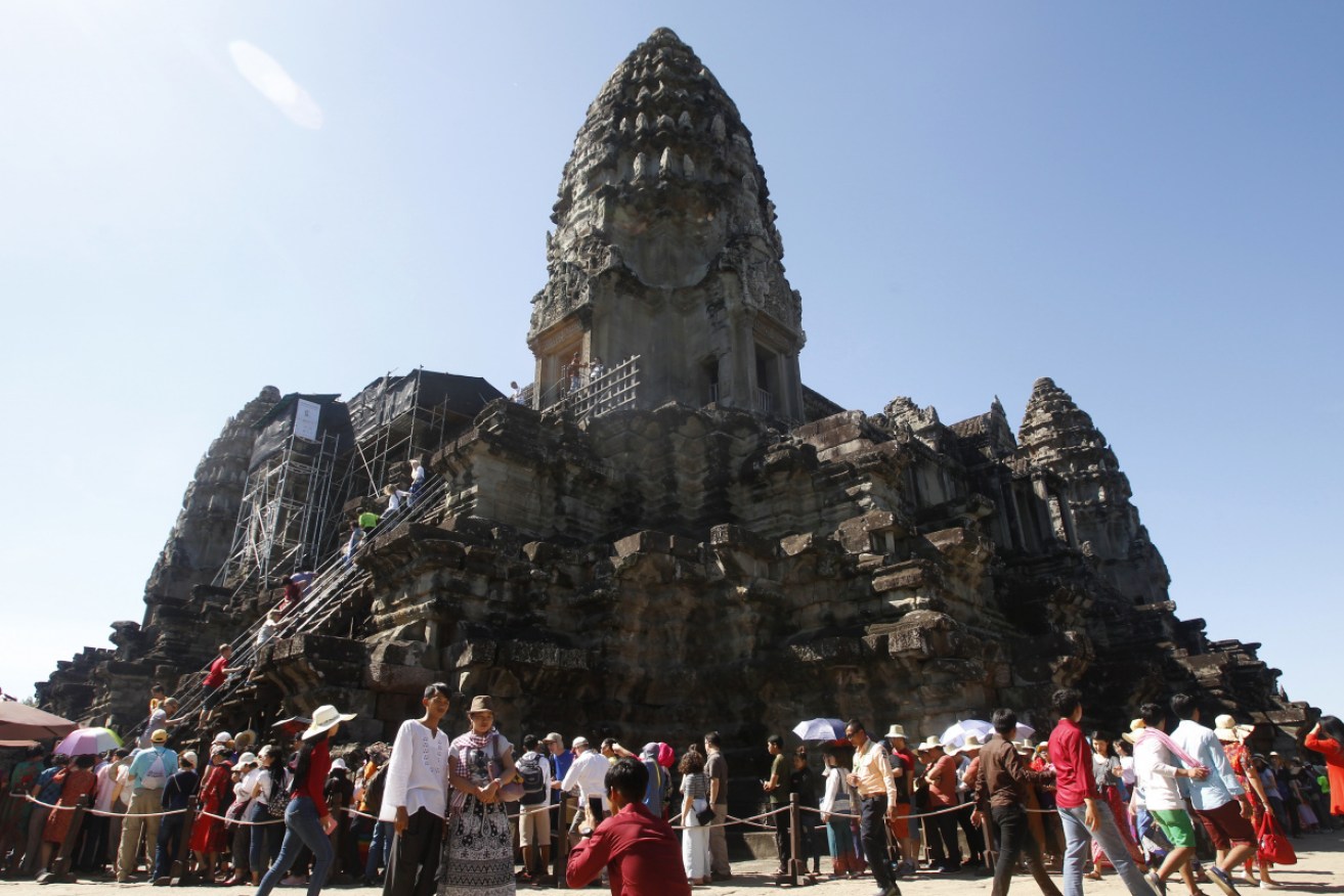 Tourists line up for stepping up the Angkor Wat temple outside Siem Reap, Cambodia.