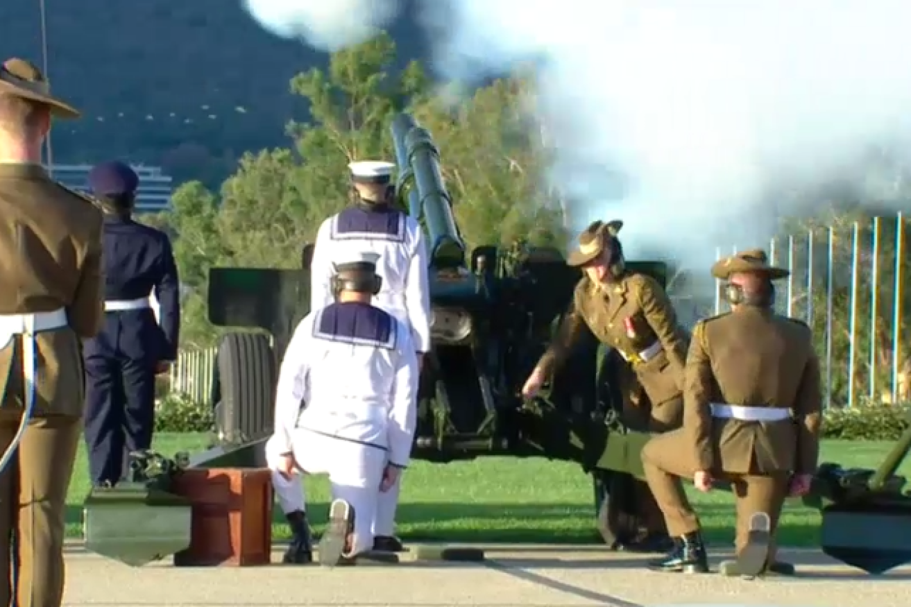 ADF servicepeople representing the Army, Navy and Air Force pay Australia's respects in billowing clouds or artillery smoke.