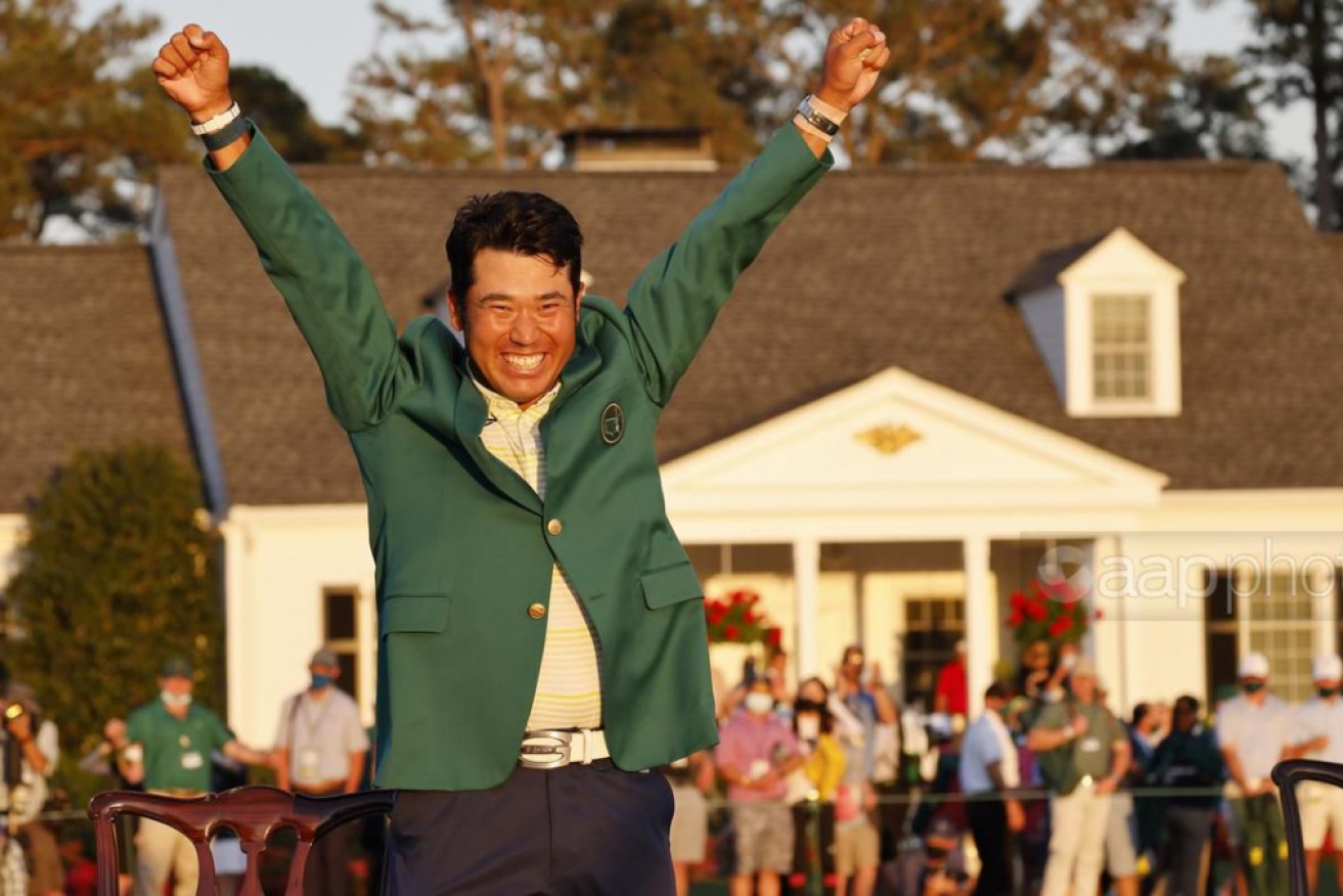 Hideki Matsuyama celebrates his Masters triumph with the champion's green jacket.
