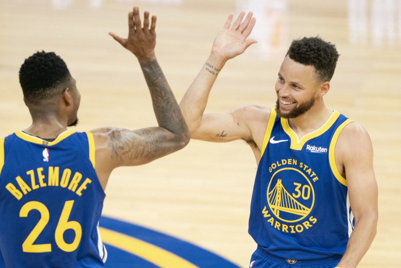 Golden State Warriors guard Stephen Curry, right, celebrates with teammate Kent Bazemore.
