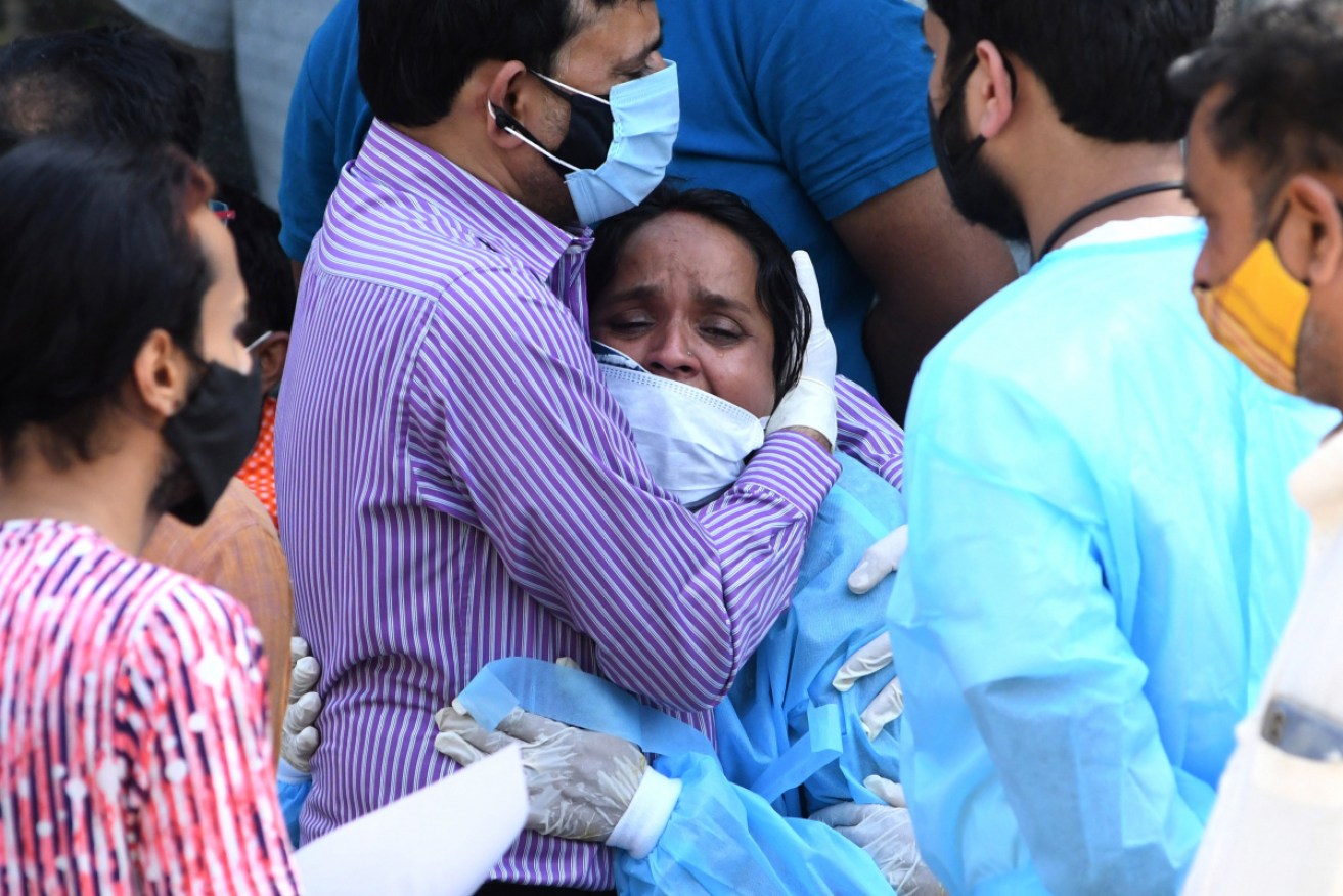 Relatives mourn during the last rites of a COVID-19 victim at a crematorium in Delhi, where cases are surging. 