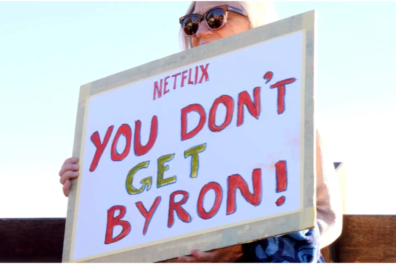 A woman holds a sign at Tuesday morning's protest.