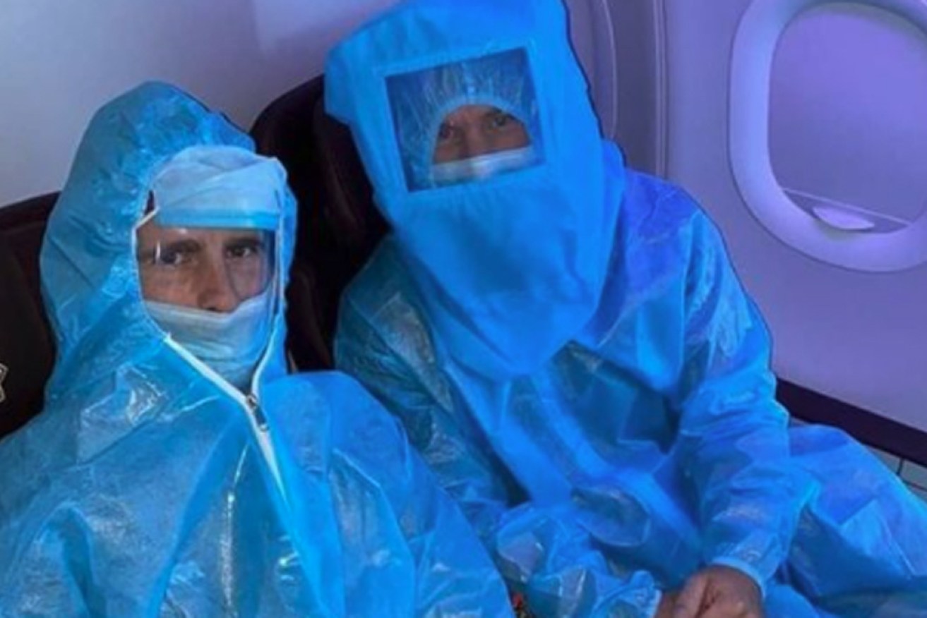 Australia's David Warner (right) with NZ's Kane Williamson in full PPE on an Indian domestic flight this week.