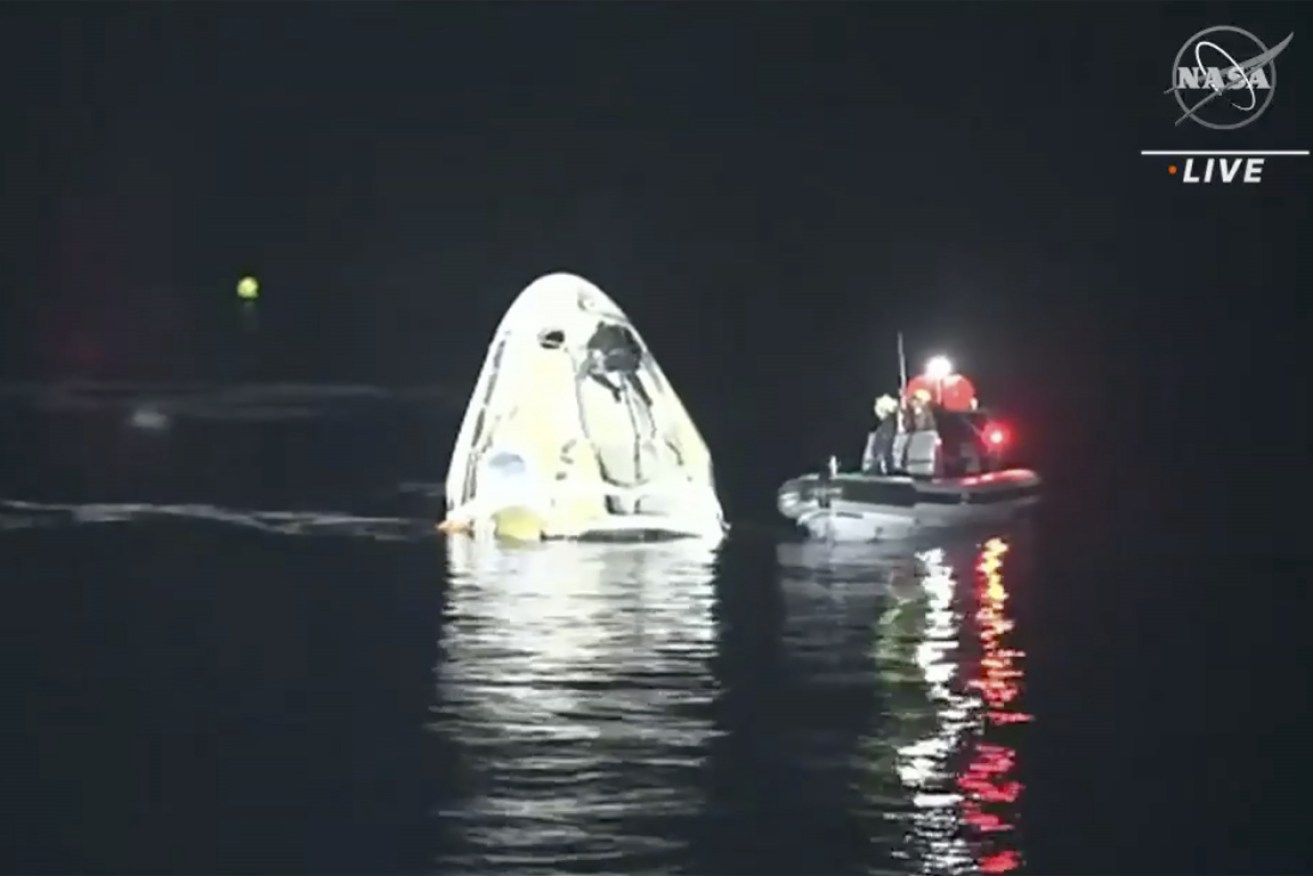 The Dragon capsule is recovered after the night splashdown. 