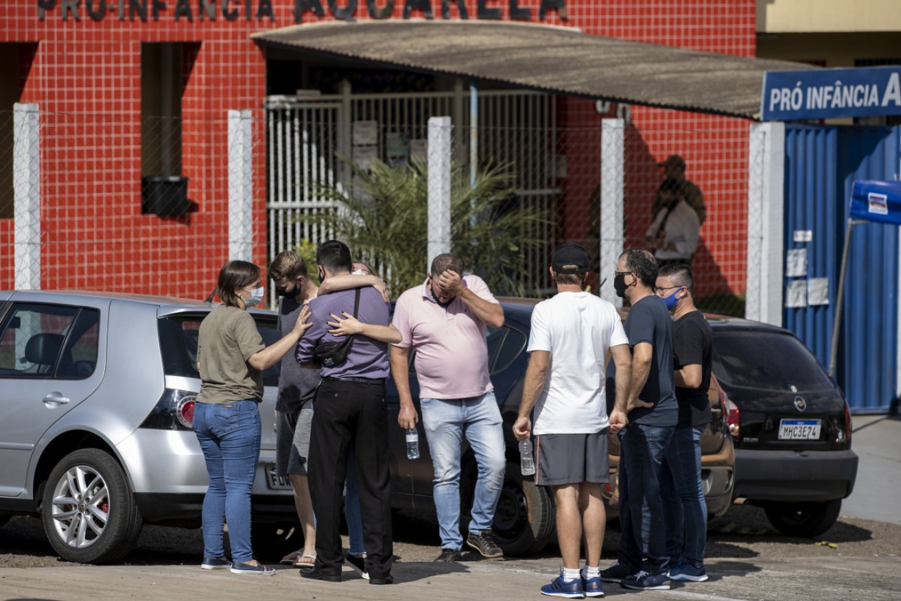 Relatives gather outside the preschool after the knife attack that killed three children and two staff.