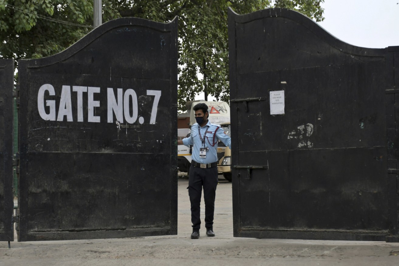 A security guard closes the gate of New Delhi's Arun Jaitley Stadium, used for the suspended Indian Premier League.