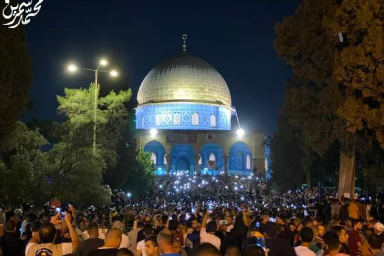 Palestinians gather in their thousands outside the Dome of the Rock mosque in Jerusalem.