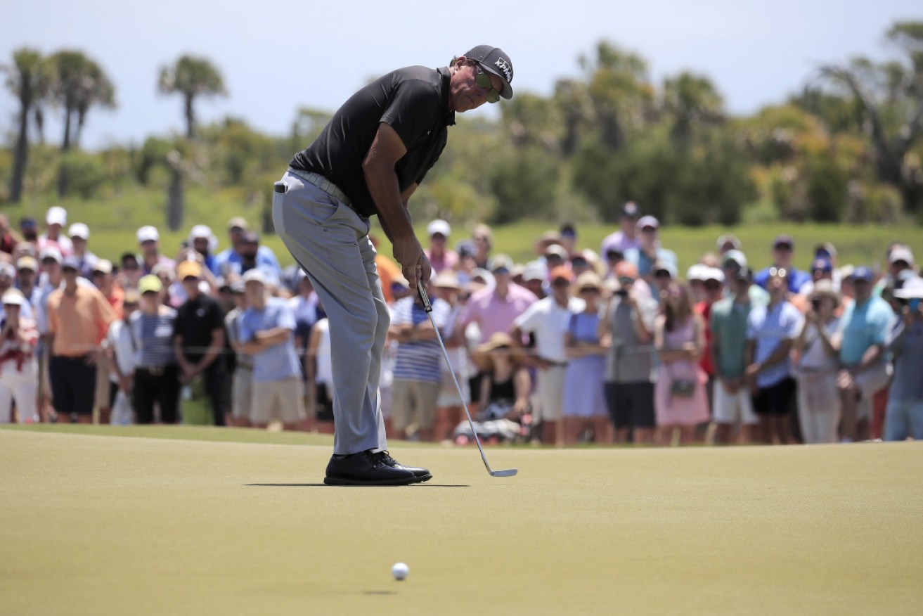 Phil Mickelson putts on his way to a share of the lead after 36 holes of the PGA Championship.