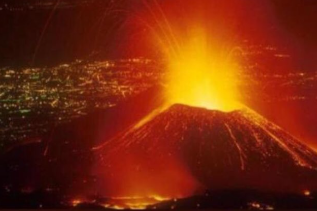 Awakened from its  slumber, Mount Nyiragongo threatens the town of Goma whose lights can be seen in the background.