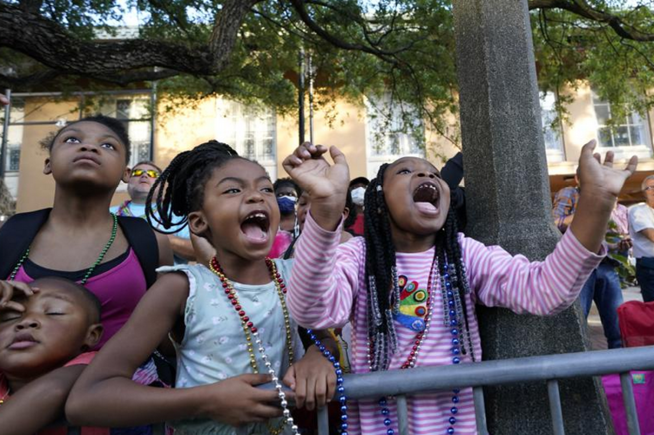 No masks and no fear for these youngsters enjoying the fun of a parade in Mobile, Alabama.