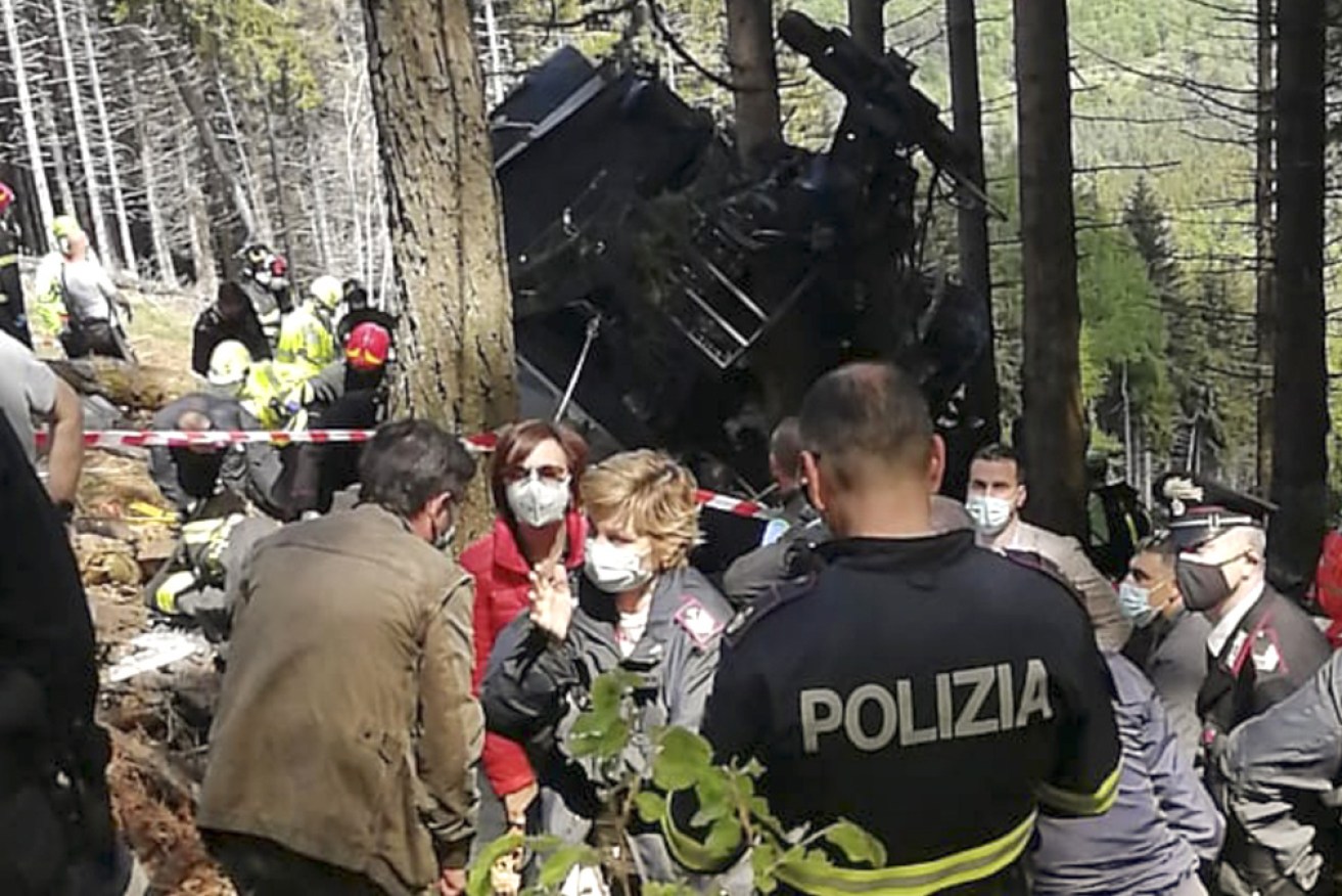 Rescuers on the scene of the fallen cable car, where 14 people died. Photo: AAP