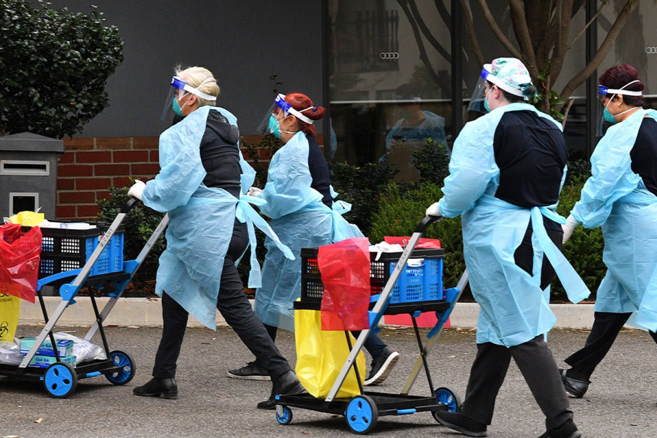 Healthcare workers seen arriving to the Arcare Aged Care facility in Maidstone.