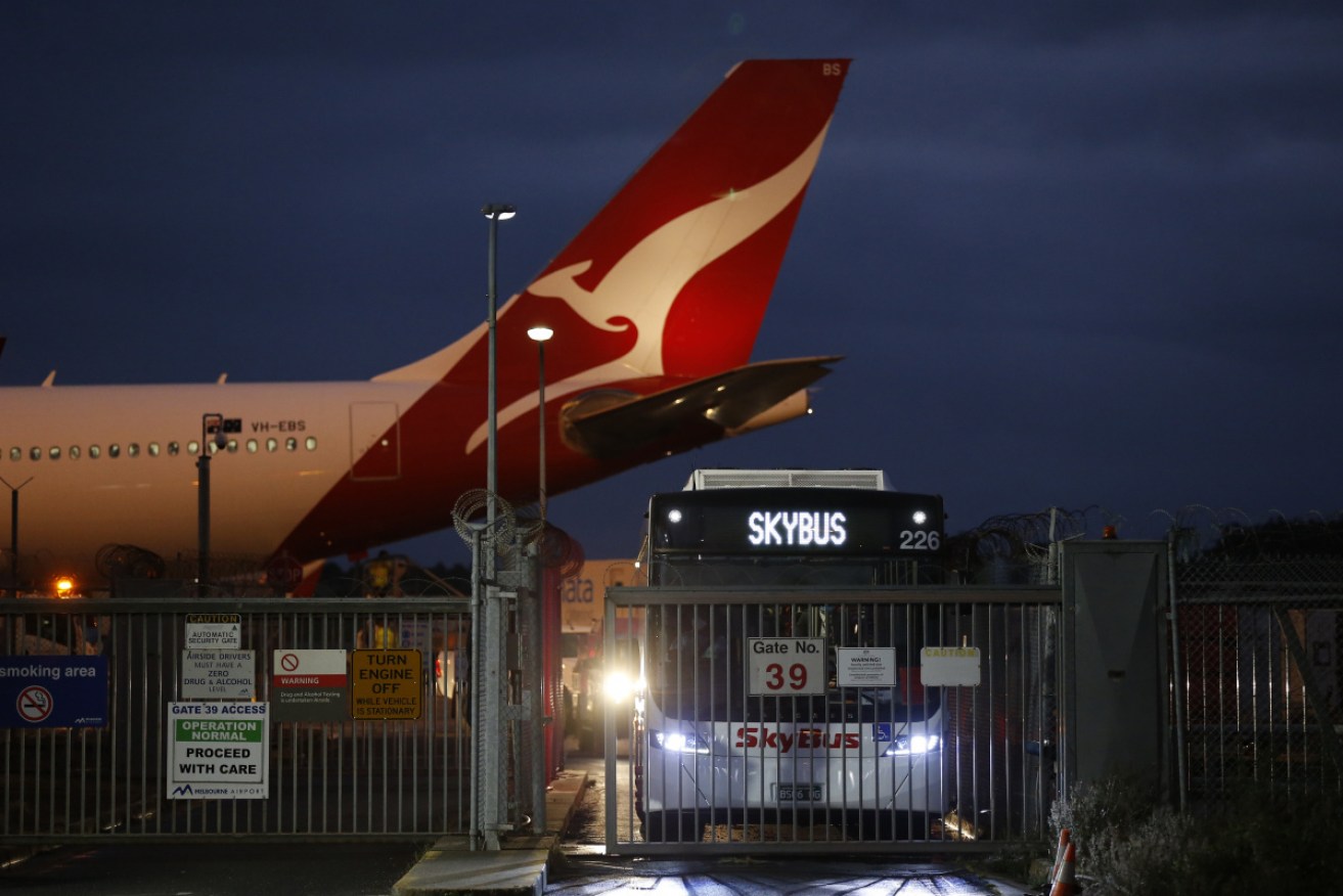 Travellers off a Qantas repatriation flight that landed in Darwin from India head into quarantine.