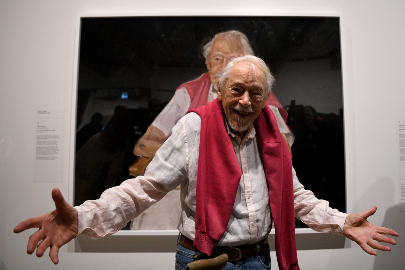 Guy Warren in front of the Archibald Prize-winning portrait of him by Peter Wegner.