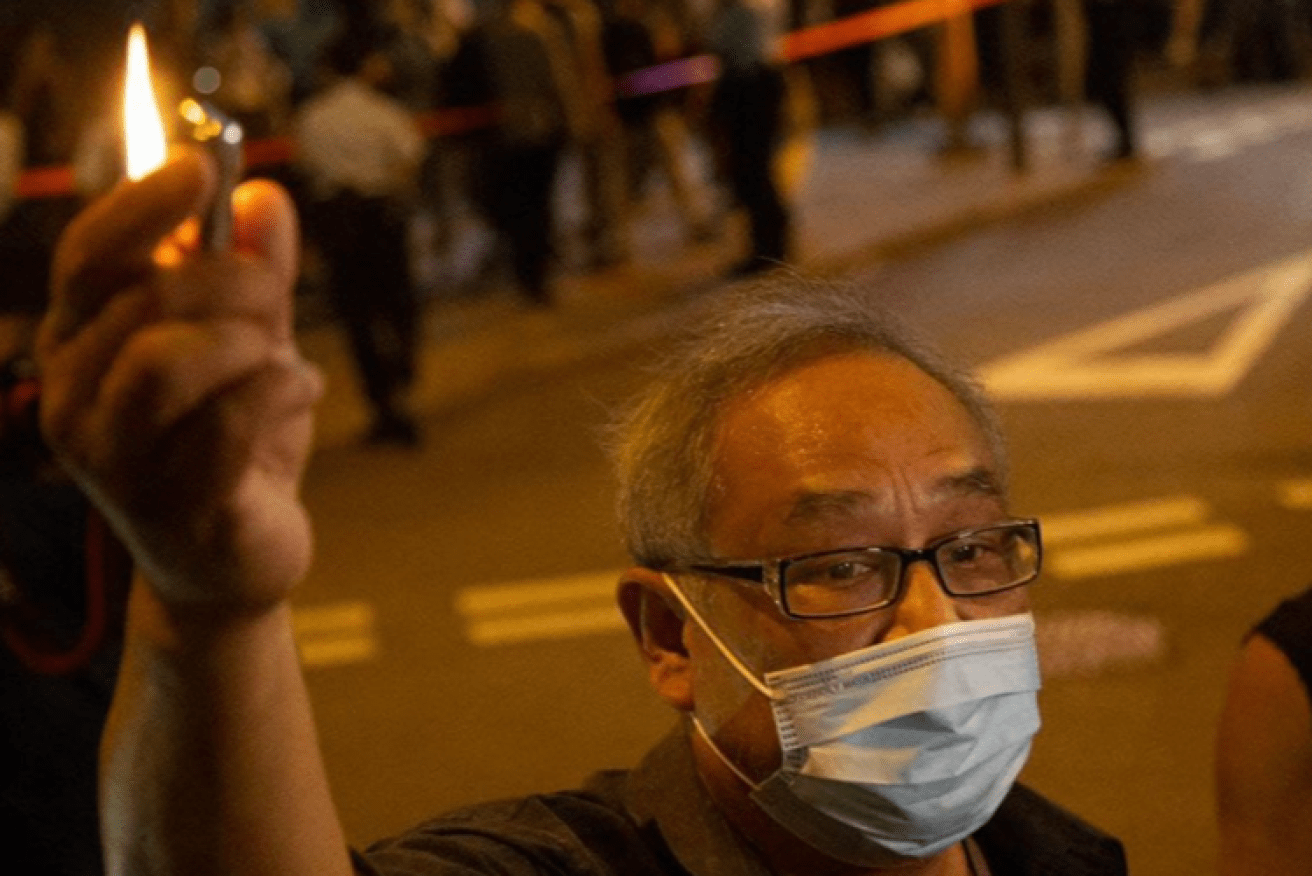 A Hong Kong resident holds aloft his cigarette lighter in a spontaneous protest against China's suppression of liberty.