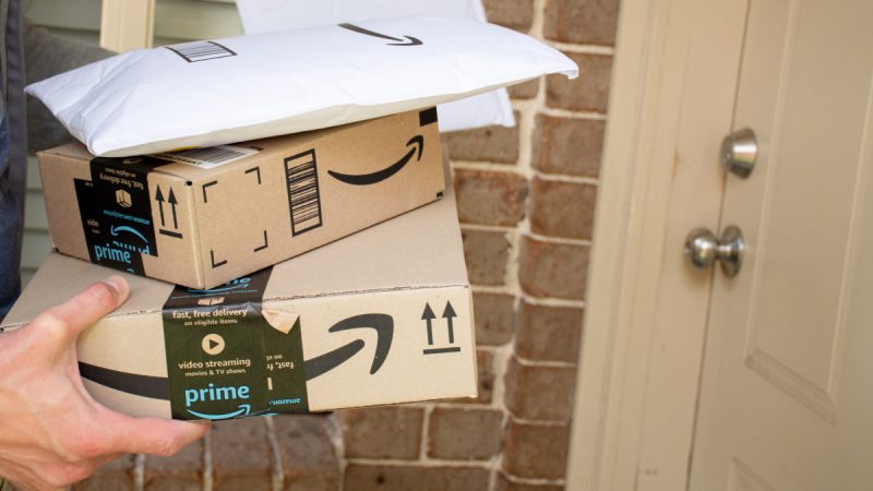 Amazon prime boxes and envelopes delivered to a front door of residential building - stock photo