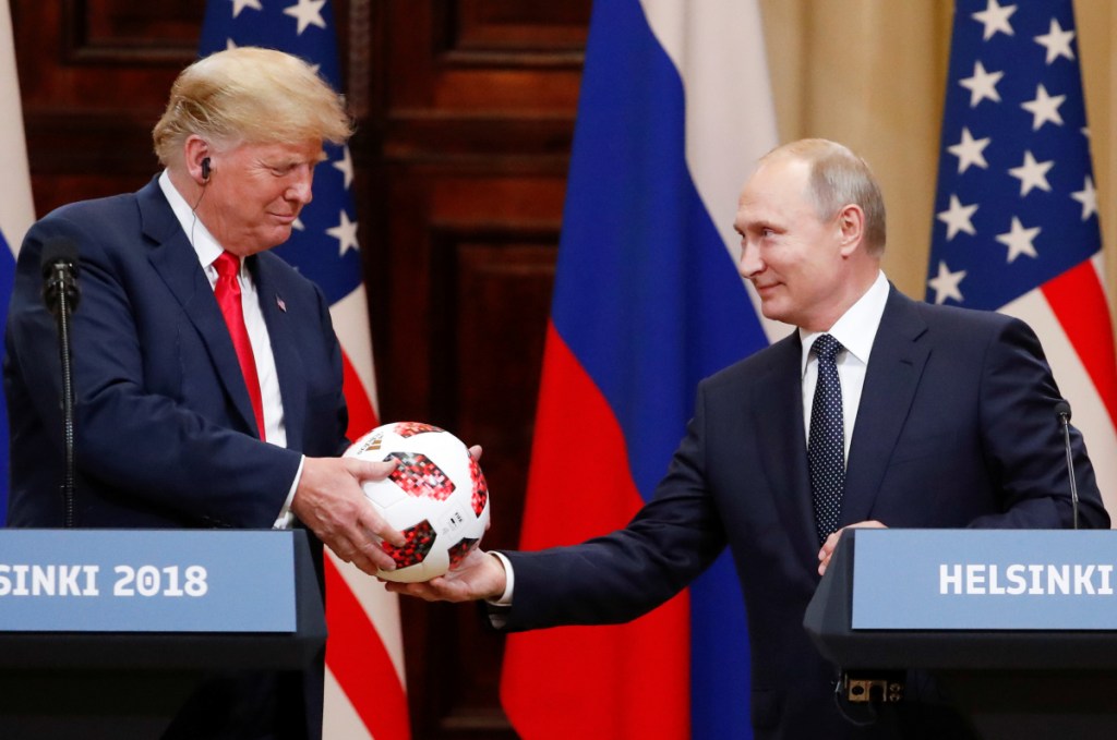 U.S. President Donald Trump receives a football from Russian President Vladimir Putin as they hold a joint news conference after their meeting in Helsinki, Finland July 16, 2018.