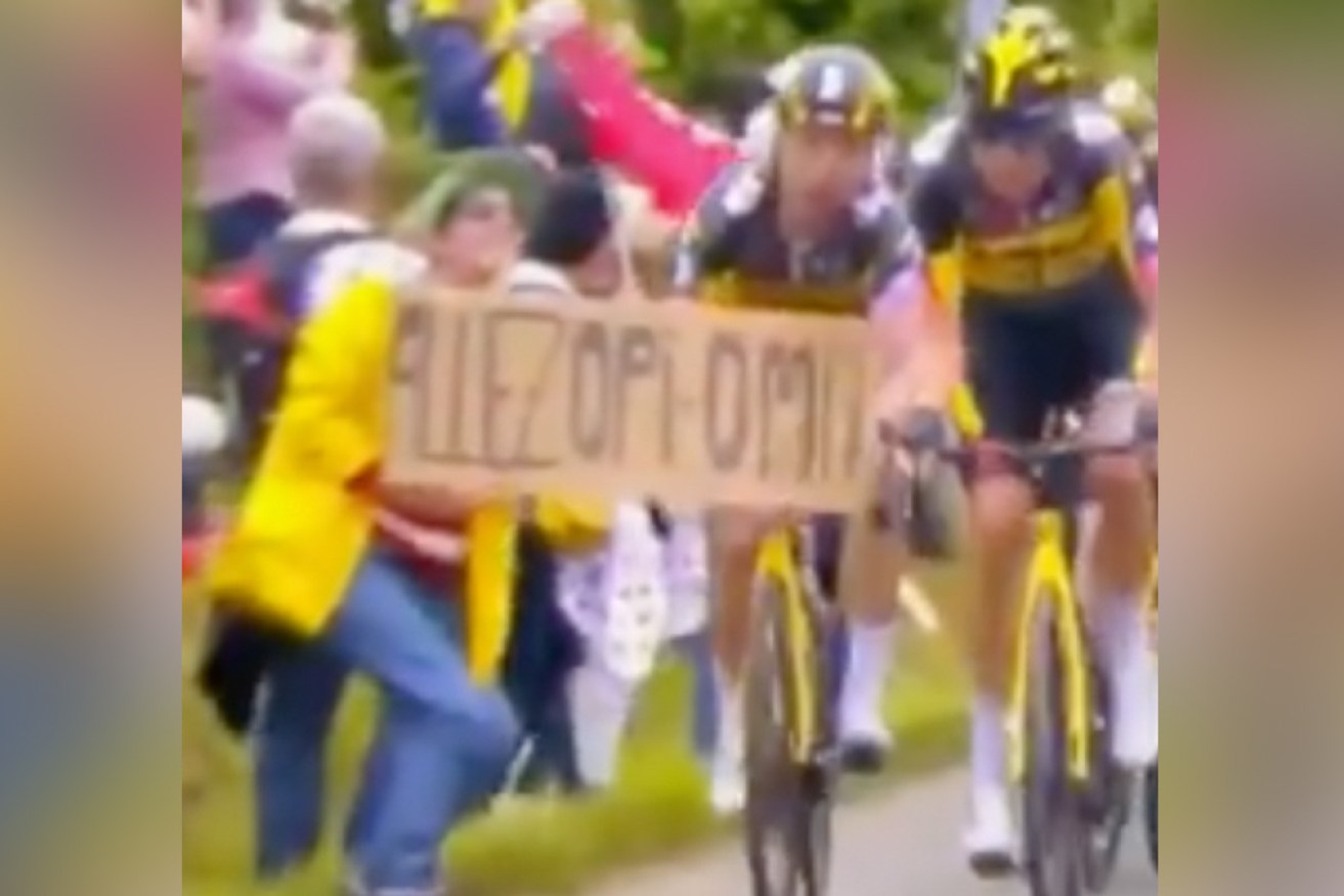 The fan stepped out in front of the speeding riders with a sign greeting her grandparents.