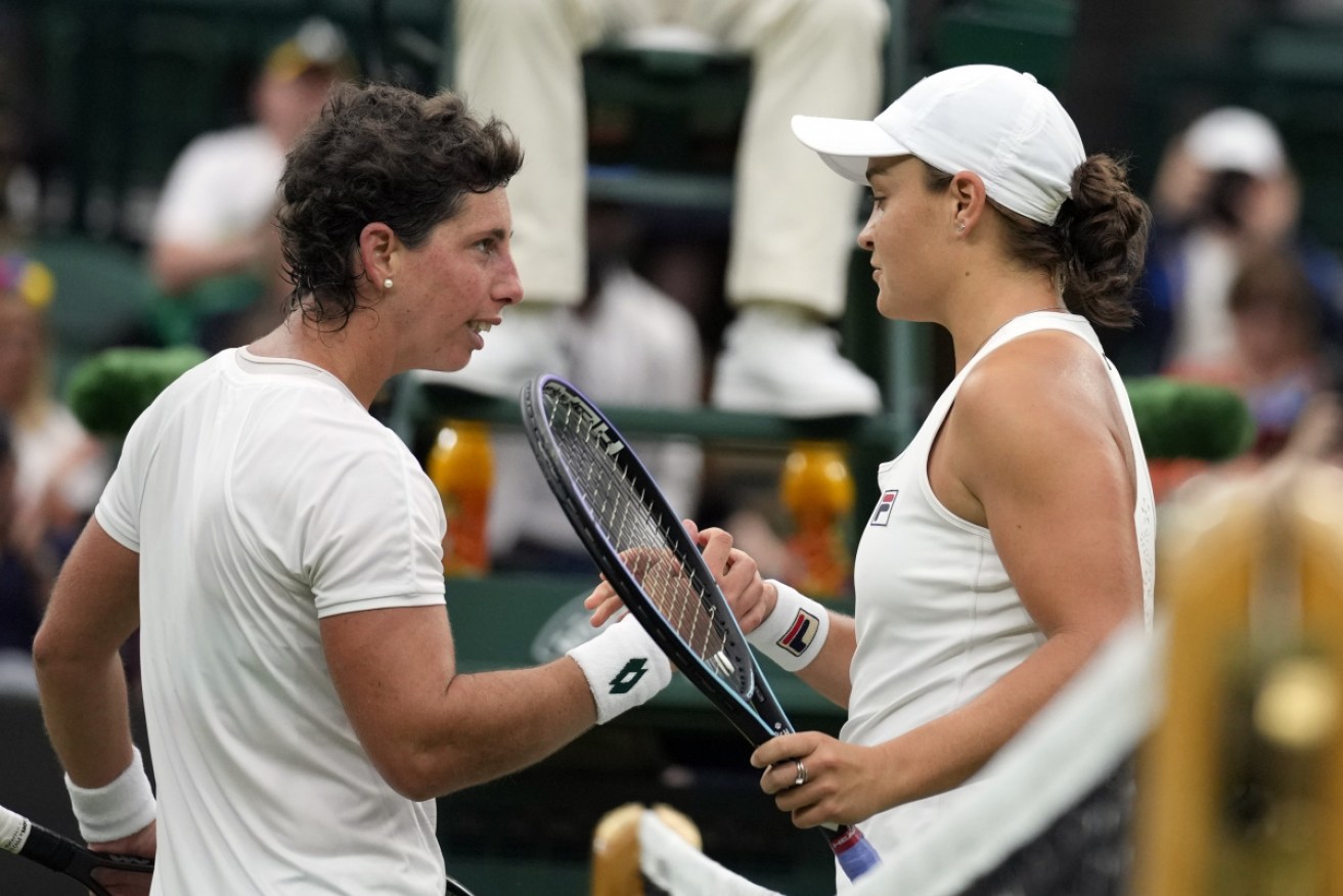 Ash Barty (right) salutes Carla Suarez Navarro at the net after their emotional first-round match.