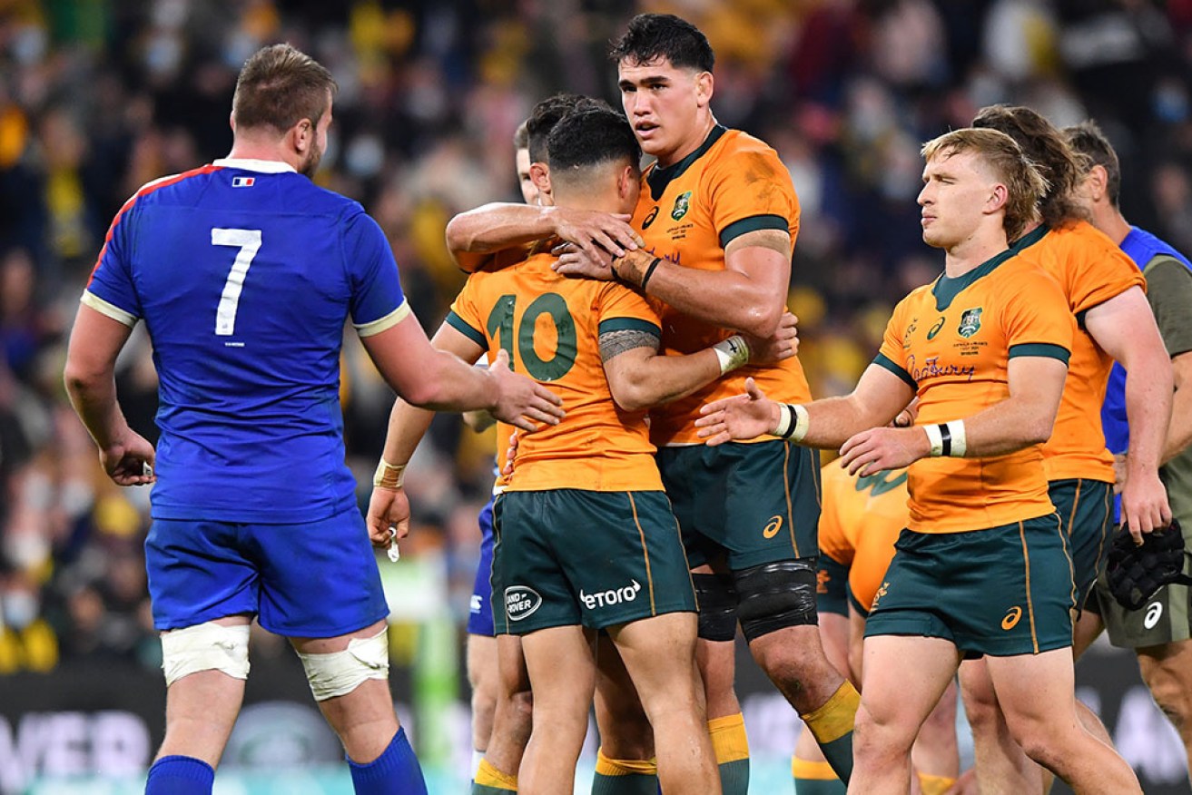 Noah Lolesio (No.10) celebrates with Wallabies teammates after kicking the winning goal against France.