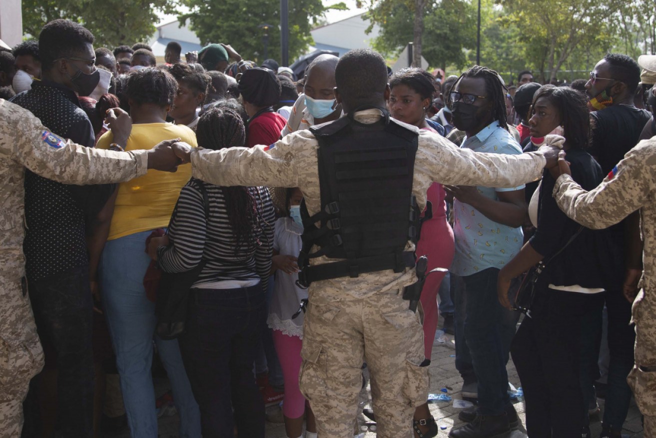 Haitian Police holds hands forming a cordon in front of the US Embassy in Port-au-Prince, Haiti. 