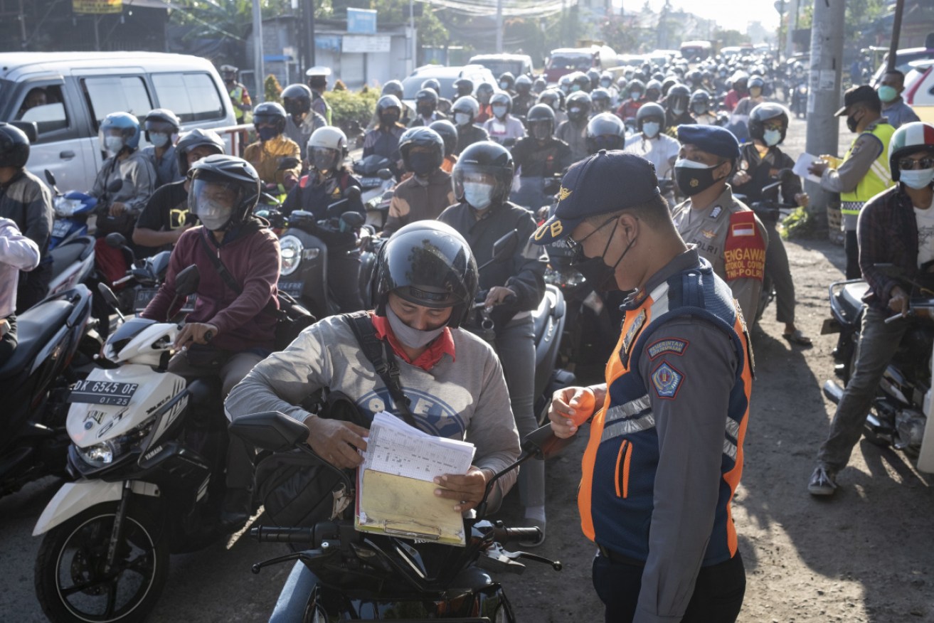 Indonesian police enforce COVID-19 restrictions in Denpasar, Bali. 
