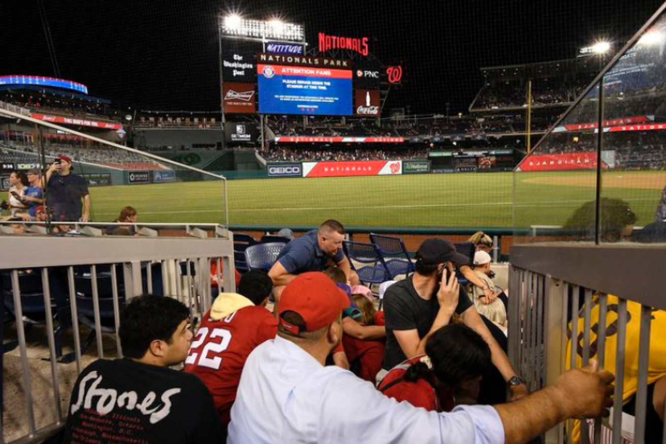 Terrified fans huddle between the seats during the incident at Nationals Stadium.