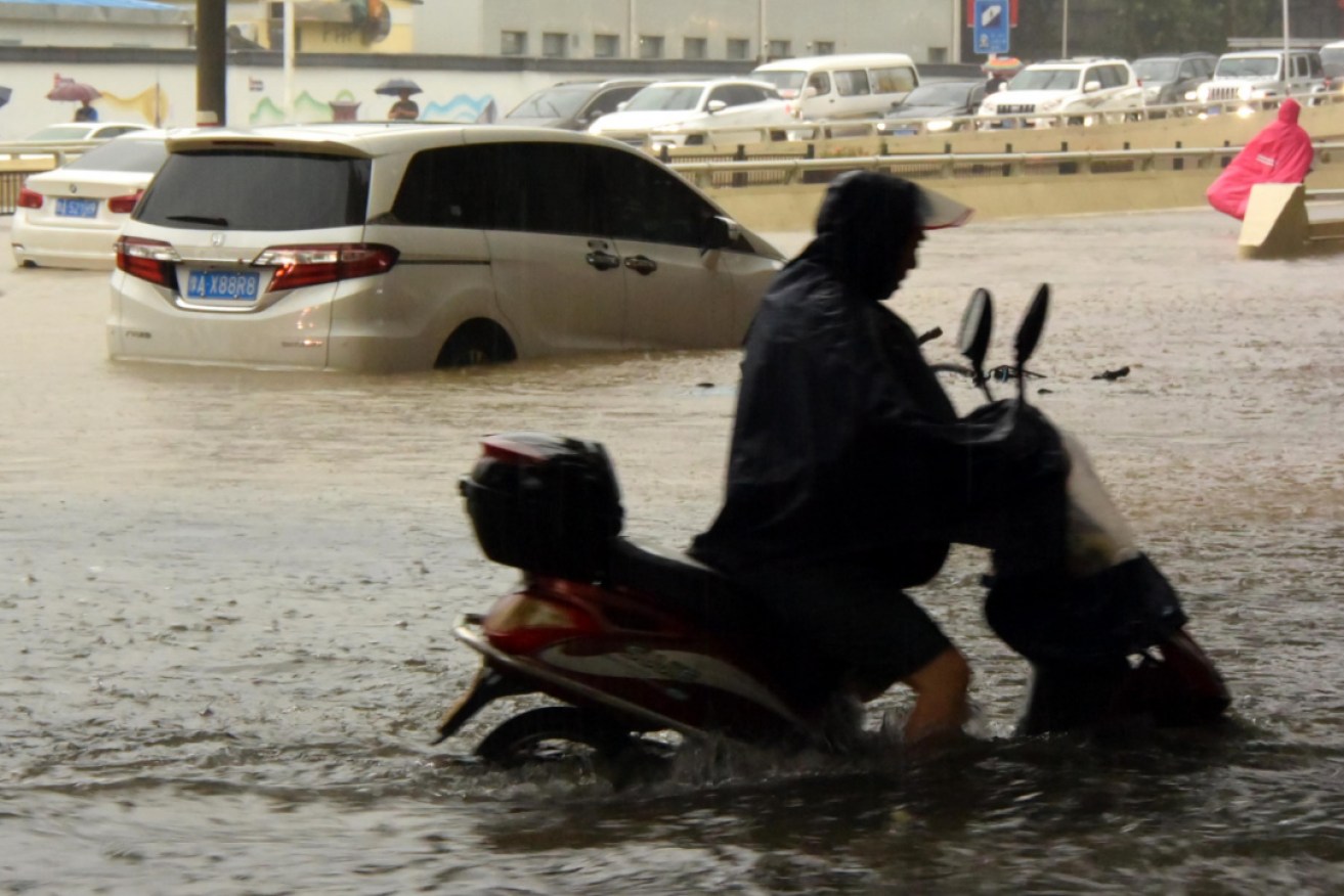 A man rides on a waterlogged road in Zhengzhou, where there has been days of rain.