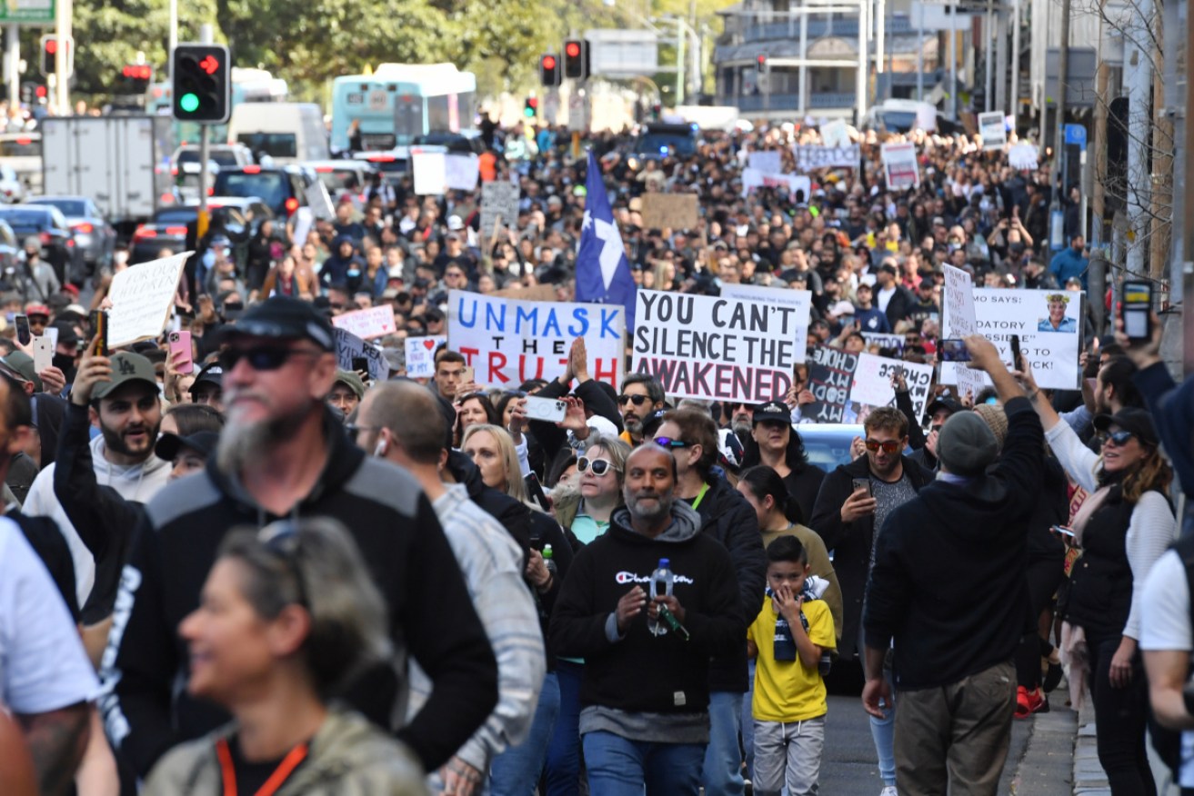 Thousands of angry, unmasked people have rallied against lockdowns in Sydney and Melbourne.
