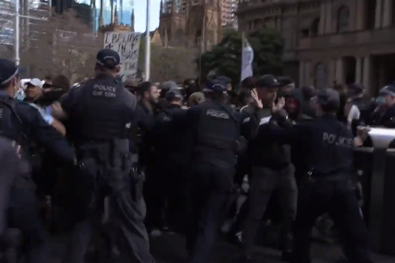 Police grapple with the front ranks of protesters at Sydney's massive anti-lockdown demonstration.