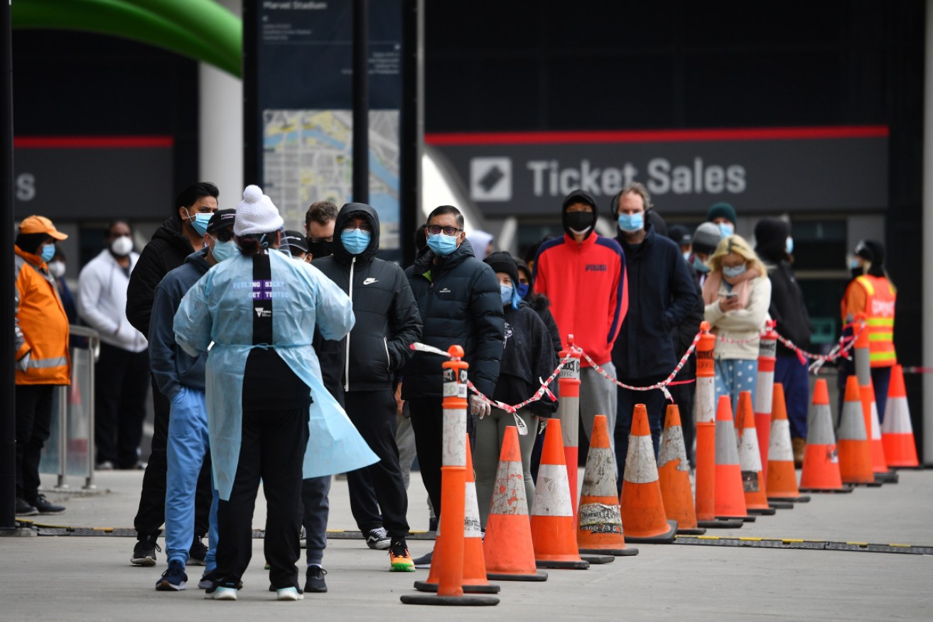 People wait at a pop-up COVID-19 testing facility outside of the LaCrosse apartments in Docklands, Melbourne on Sunday.