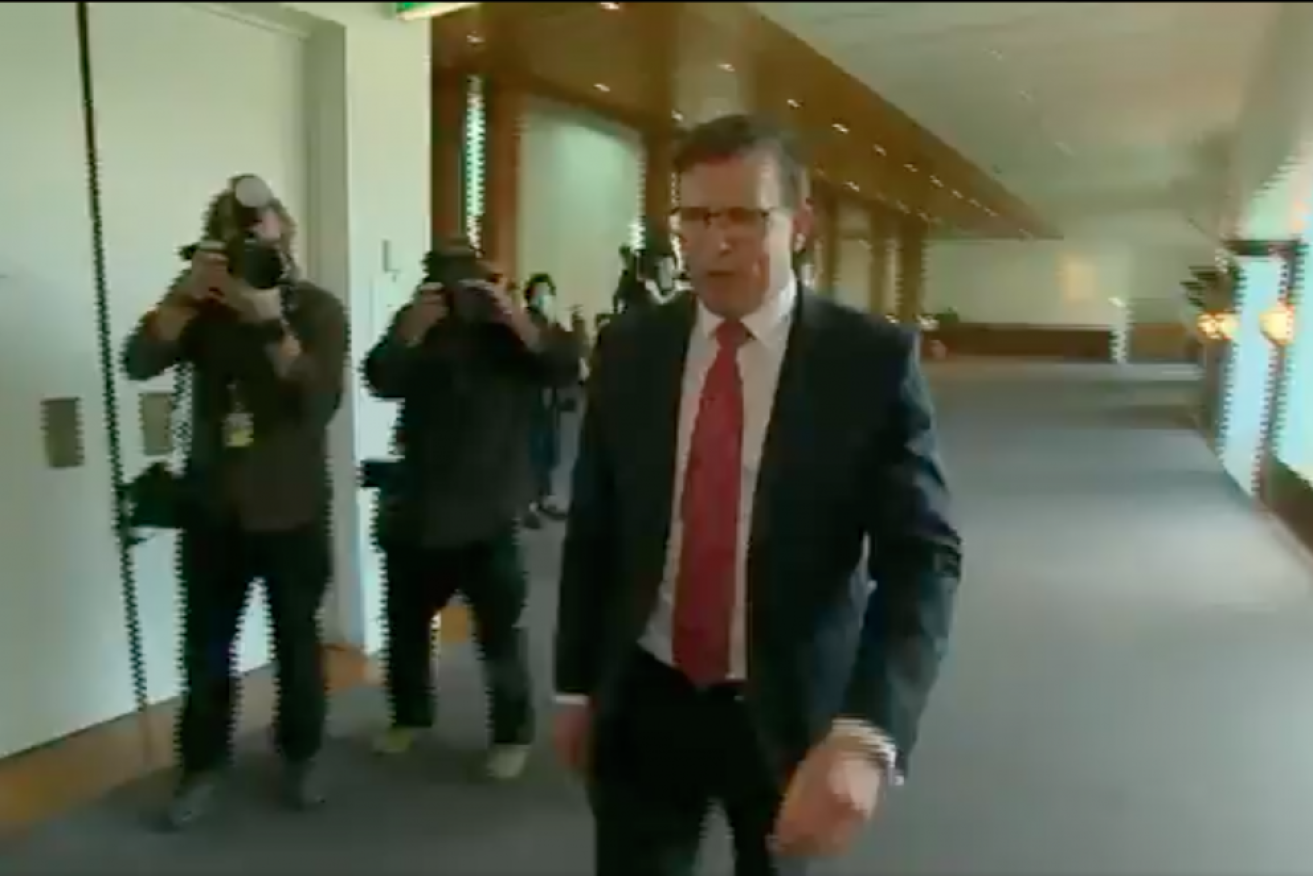 Alan Tudge walks off while being questioned.