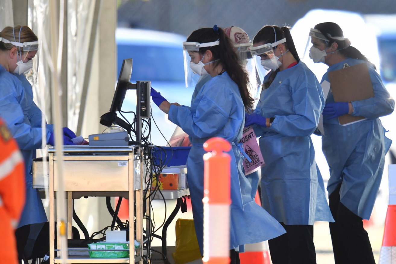 Health care workers at a pop-up COVID-19 testing clinic at Indooroopilly State High School in Brisbane on Wednesday.