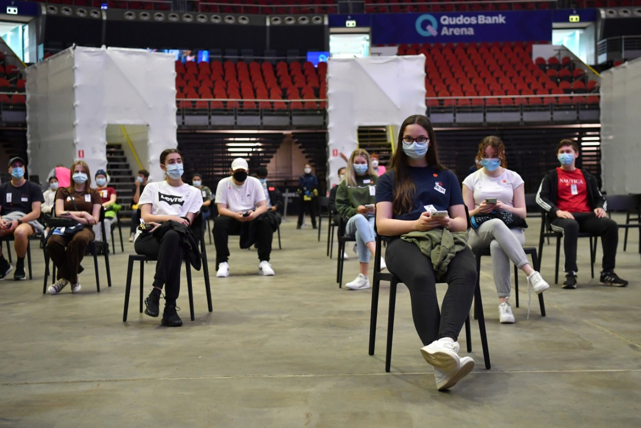 Year 12 HSC students wait for their Pfizer vaccinations at Sydney’s Qudos Arena on Monday.