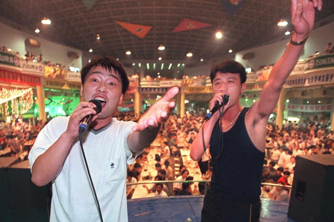 Two karaoke singers entertain the crowd at the Qingdao International Beer Festival.