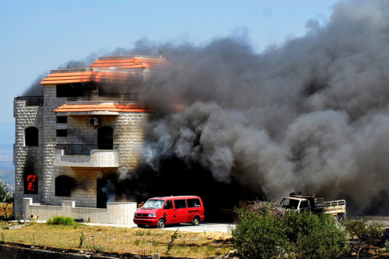 Smoke pours from the home that served as a front for the blackmarketeers' illegal petrol storage site.