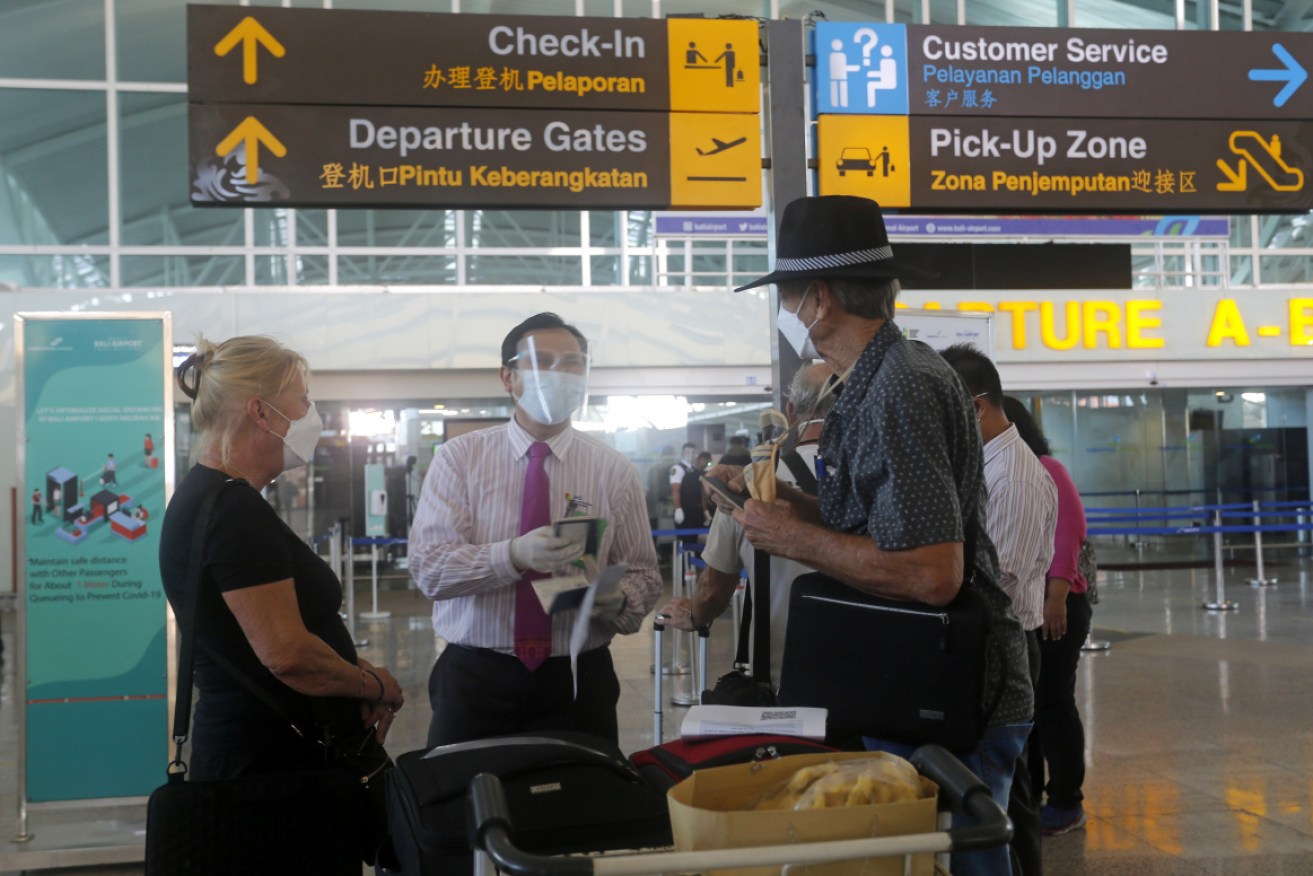 Australians are checked at Bali's international airport before their repatriation flight. It has since landed in Darwin.