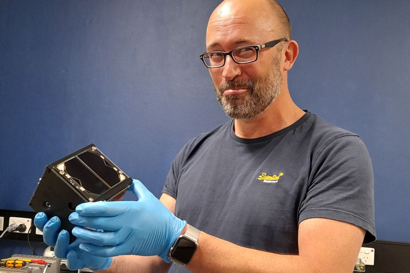 Curtin University's Phil Bland holding the Binar-1 Cubesat satellite, the first WA-built spacecraft. 